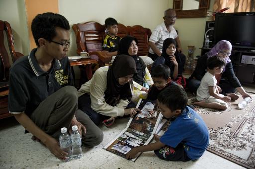 The family of Norliakmar Hamid, a missing Malaysian passenger on flight MH370 gather in their family home to await news. (Photo credit: AFP / Mohd Rasfan)  