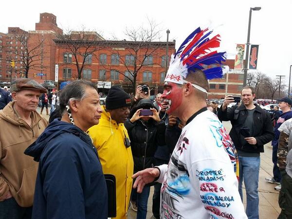 A now infamous image of a R*dskins fan in redface, being confronted by a member of the Native community.