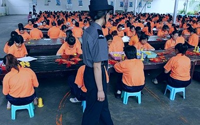 Inmates in a Chinese labor camp work under watch of a guard.