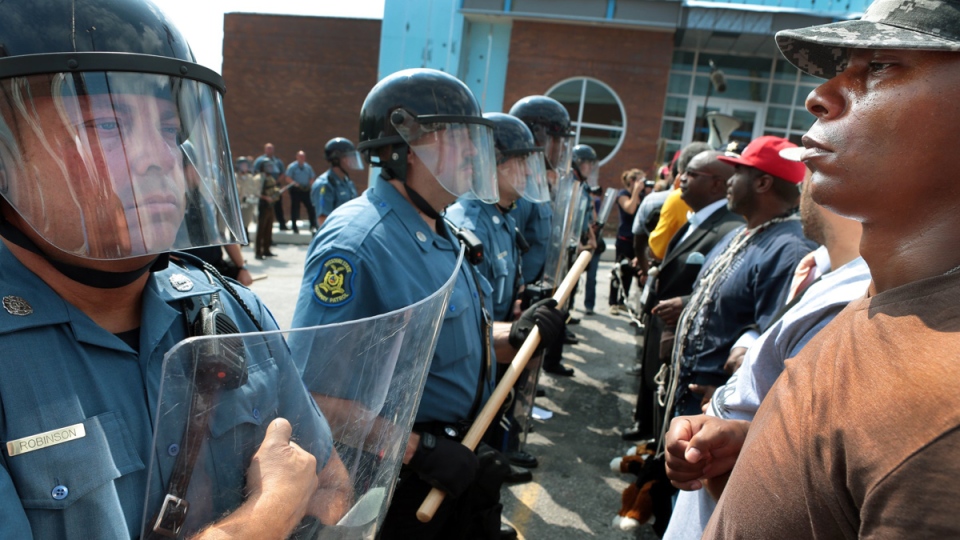Riot police are dispatched to Ferguson, to "protect" residents from a peaceful congregation of Black protesters.