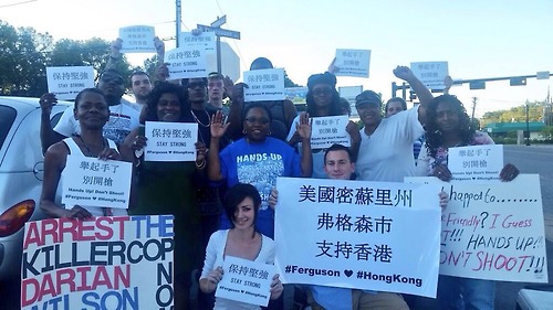 Ferguson protesters hold up signs in solidarity with the Hong Kong protests.