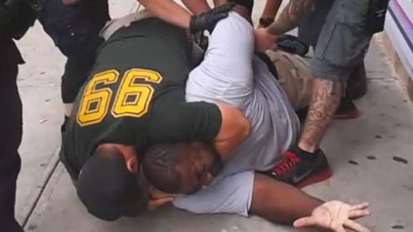 Image of NYPD wrestling with Garner and placing him in a chokehold, moments before his death.