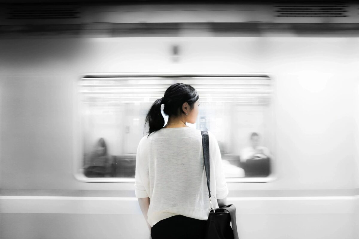 A woman stands on a subway platform. Photo credit: Stock Photo